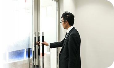 出社時にドアノブに手をかける加々美祐和