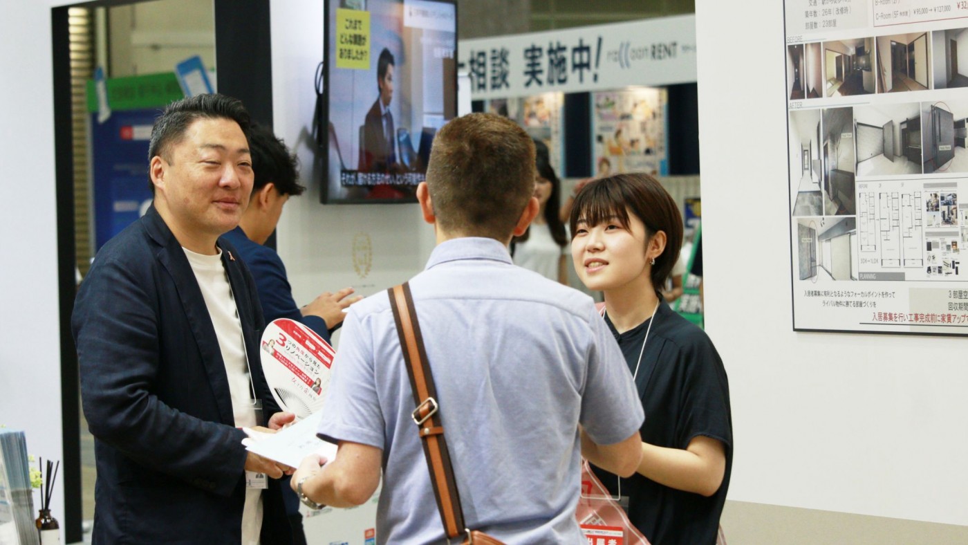 展示ブースで朝日リビングスタッフと話している男性