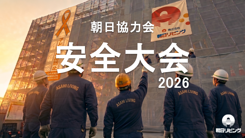 安全大会2026の文字と現場の足場を見上げる作業着姿の参加者たち